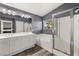 Bright bathroom featuring double sinks, soaking tub, glass shower, and wood-look floors at 232 Dog Leg Dr, Las Vegas, NV 89148