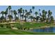 Beautiful golf course view with green grass, palm trees, sand traps, and serene water feature at 232 Dog Leg Dr, Las Vegas, NV 89148