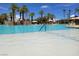 Large community pool with palm trees, lounge chairs, water features, and shallow end at 232 Dog Leg Dr, Las Vegas, NV 89148
