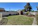 Fenced backyard featuring a grassy area, mature tree, and storage shed at 2381 Marion St, Las Vegas, NV 89104