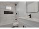Bathroom features a shower-over-tub with marble tile and a built-in dark tiled niche, a stylish mirror, and modern vanity at 2381 Marion St, Las Vegas, NV 89104