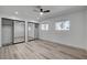 Bright bedroom with ceiling fan, wood-style flooring, and mirrored closet doors at 2381 Marion St, Las Vegas, NV 89104