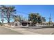 Charming single-story home featuring a decorative fence, mature trees, and a gated entrance, enhancing curb appeal at 2381 Marion St, Las Vegas, NV 89104