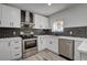 Modern kitchen featuring white cabinets, stainless steel appliances, and dark backsplash at 2381 Marion St, Las Vegas, NV 89104