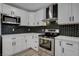 This kitchen features white cabinets, stainless steel appliances, and a black backsplash at 2381 Marion St, Las Vegas, NV 89104
