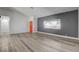An open-concept living area with wood-look floors, a painted accent wall and an orange door at 2381 Marion St, Las Vegas, NV 89104