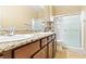 Bright bathroom featuring double sinks, granite countertops, a large mirror, and wood cabinets at 2612 Tullamore Creek Ln, Laughlin, NV 89029