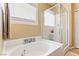 Bright bathroom featuring a soaking tub with glass shower doors and a window at 2612 Tullamore Creek Ln, Laughlin, NV 89029