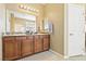 Bright bathroom featuring double sinks with granite countertops, a large mirror, and wood cabinets at 2612 Tullamore Creek Ln, Laughlin, NV 89029