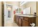 Bright bathroom featuring double sinks with granite countertops, a large mirror, and wood cabinets at 2612 Tullamore Creek Ln, Laughlin, NV 89029