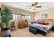 Bedroom with a ceiling fan, dresser, and windows providing natural light and backyard views at 2612 Tullamore Creek Ln, Laughlin, NV 89029