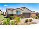 Charming single-story home featuring a desert landscape, stone accents, and a two-car garage at 2612 Tullamore Creek Ln, Laughlin, NV 89029