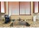 Close-up of the kitchen sink featuring granite countertops, a stainless steel faucet, and a bright window at 2612 Tullamore Creek Ln, Laughlin, NV 89029