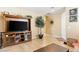 Neutral living room with tile flooring, a large TV console, and ample natural light at 2612 Tullamore Creek Ln, Laughlin, NV 89029