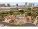 An aerial view shows the property with a circular driveway, palm trees, and the city in the distance at 3207 Bel Air Dr, Las Vegas, NV 89109