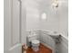 Charming powder room with pedestal sink, hexagon window, and wood-look tile floors at 3207 Bel Air Dr, Las Vegas, NV 89109