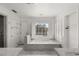 Bright bathroom with marble tiling, soaking tub, and shuttered window for relaxing comfort at 3207 Bel Air Dr, Las Vegas, NV 89109