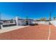 The backyard features red rock landscaping, a white block wall, and a covered patio area at 3212 Hickey Ave, North Las Vegas, NV 89030