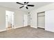 This bedroom features neutral carpet, a ceiling fan, closet and bathroom access at 3212 Hickey Ave, North Las Vegas, NV 89030