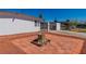 Front yard featuring decorative tree stump, red rock landscaping, and gated entrance at 3212 Hickey Ave, North Las Vegas, NV 89030