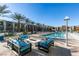 Relaxing pool area featuring an in-ground pool, lounge chairs, couches, and palm trees at 353 E Bonneville Ave # 289, Las Vegas, NV 89101