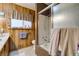 Bathroom featuring wood paneled walls, shower-tub combo with glass doors, and a single sink vanity at 4476 Oakhill Cir, Las Vegas, NV 89121