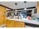 An eat-in kitchen featuring light wood cabinets and an adjoining living space with wood beams at 4476 Oakhill Cir, Las Vegas, NV 89121