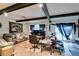 Spacious living room featuring wood floors, exposed ceiling beams, and a sliding glass door to the backyard at 4476 Oakhill Cir, Las Vegas, NV 89121