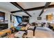 Living area featuring wood beams, stone fireplace, and connection to the outdoors at 4476 Oakhill Cir, Las Vegas, NV 89121