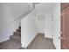 Hallway with carpeted staircase, neutral wall colors, and multiple doors at 4561 Woolcomber St, Las Vegas, NV 89115