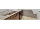 Kitchen featuring double basin sink, dark cabinets, granite counters, and tan and beige floor tiles at 4561 Woolcomber St, Las Vegas, NV 89115