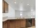 Kitchen featuring granite countertops, double basin sink, dark wood cabinets, and stainless steel dishwasher at 4561 Woolcomber St, Las Vegas, NV 89115