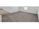 Neutral-toned carpeted living room with white walls, and view of the exterior from the window at 4561 Woolcomber St, Las Vegas, NV 89115