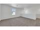 Bright living room featuring neutral carpet, white walls and trim, and a window with neighborhood views at 4561 Woolcomber St, Las Vegas, NV 89115