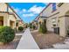 A street view showcasing the sidewalk and home exteriors, set against a bright, cloudy sky at 4561 Woolcomber St, Las Vegas, NV 89115