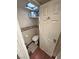 Compact bathroom with a toilet, shelf and a door with three panels and an hook to hang towels at 4830 E Comanche Dr, Pahrump, NV 89061