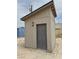 Tan shed with a gray door and black sconce at 4830 E Comanche Dr, Pahrump, NV 89061