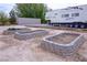 Landscaped, raised garden beds with a trailer and camper parked in the background at 4830 E Comanche Dr, Pahrump, NV 89061