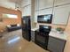 Bright kitchen featuring white upper and gray lower cabinets and black appliances at 4830 E Comanche Dr, Pahrump, NV 89061