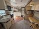 RV kitchenette with a sink, cooktop, microwave, and adjacent living and dining areas at 4830 E Comanche Dr, Pahrump, NV 89061