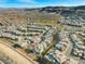 Wide aerial view of a neighborhood with many modern homes, pool, golf course and mountain views in the distance at 5231 Iron River Ct, Las Vegas, NV 89135
