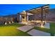 Backyard patio area features a pergola with seating, outdoor lighting, and a TV for entertainment at 5231 Iron River Ct, Las Vegas, NV 89135