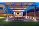 Backyard patio area with a pergola with seating, outdoor lighting, and a TV for entertaining at 5231 Iron River Ct, Las Vegas, NV 89135