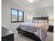 Comfortable bedroom features a queen bed with drawers, a view-framing window, and sleek bedside tables at 5231 Iron River Ct, Las Vegas, NV 89135