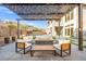 Cozy outdoor seating area with a modern pergola and a fire pit for relaxing evenings at 5231 Iron River Ct, Las Vegas, NV 89135
