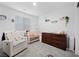Bedroom with a white rocking chair, crib, and dresser, decorated with animal themed decorations at 6144 Rathbone St, Las Vegas, NV 89166