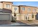 Contemporary townhouse showcasing a brick driveway, two-car garage, and neat landscaping at 6144 Rathbone St, Las Vegas, NV 89166
