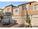 View of modern townhouse exterior with brick driveway, two-car garage, and tasteful landscaping at 6144 Rathbone St, Las Vegas, NV 89166
