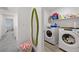 Bright laundry room featuring modern washer and dryer, shelving, and unique decor at 6144 Rathbone St, Las Vegas, NV 89166