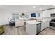Open-concept living room and kitchen with stainless steel appliances and light gray wood floors at 6144 Rathbone St, Las Vegas, NV 89166